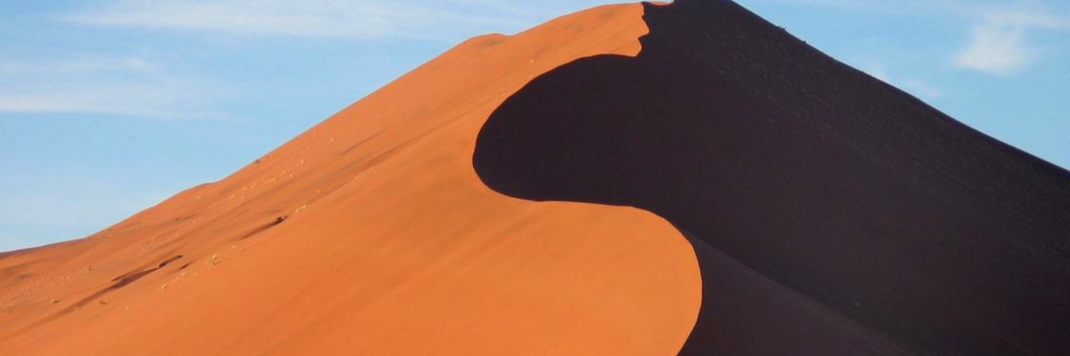 A star dune in the Namib, sharp shadow line across the crest